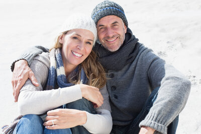 2. attractive-couple-smiling-camera-beach-warm-clothing.jpg